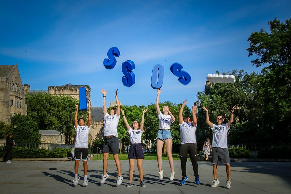 A group of ISSOS students jumping up as they throw the ISSOS letters into the air.