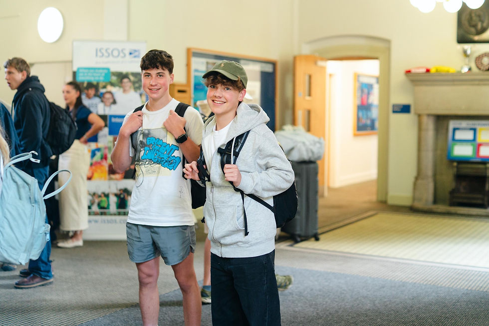 Two students smiling and talking with ISSOS staff welcome building.