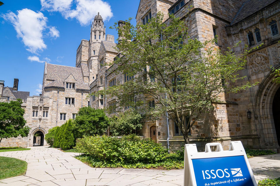 Yale courtyard with historic buildings and an ISSOS sign.