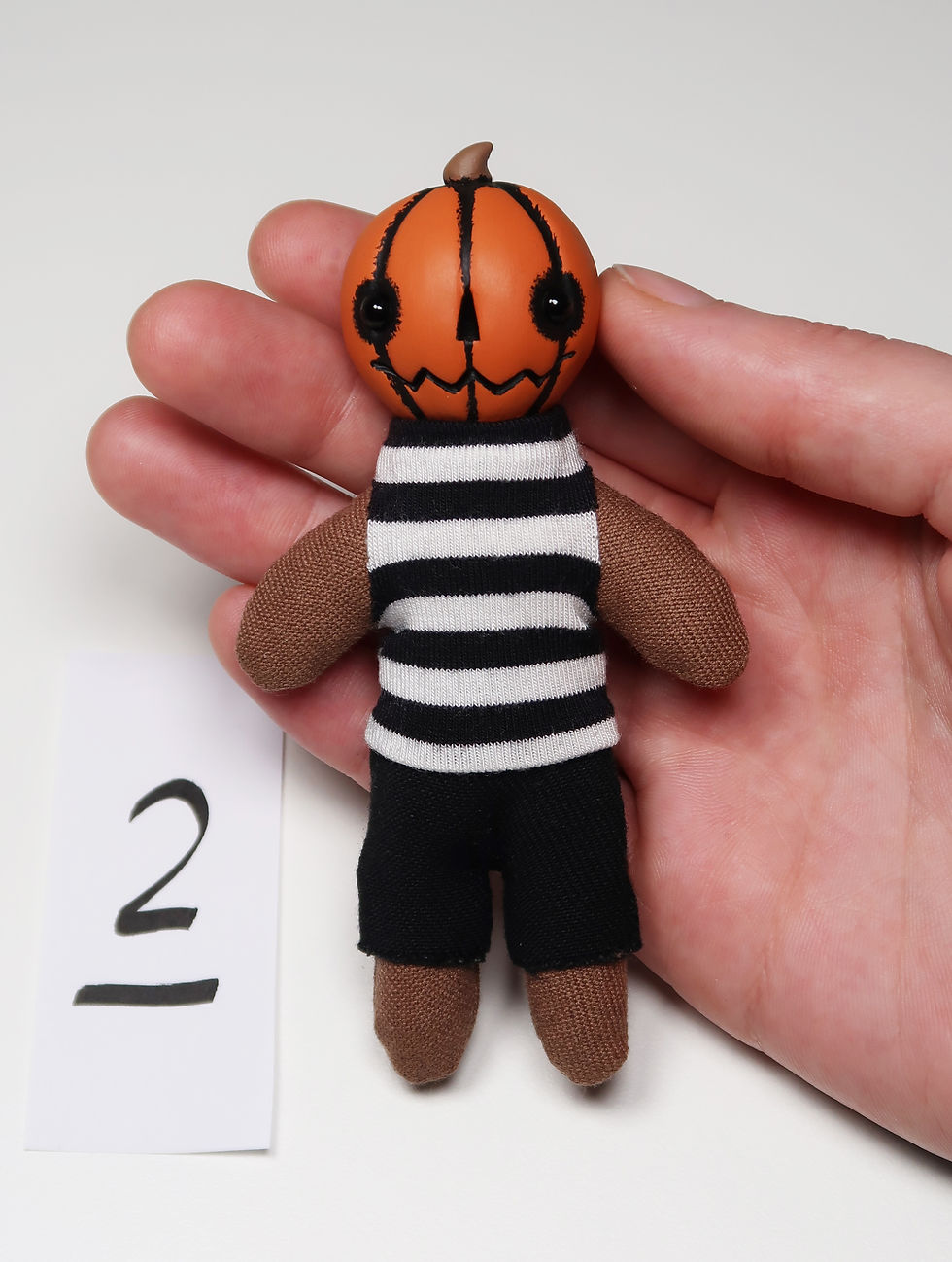 Thumbnail: 4" orange mini pumpkin doll in striped shirt