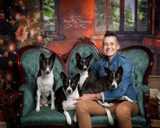 four dogs and owner sit on vintage couch posing for holiday photos with pet photographer Lisa Olson with pets r family 