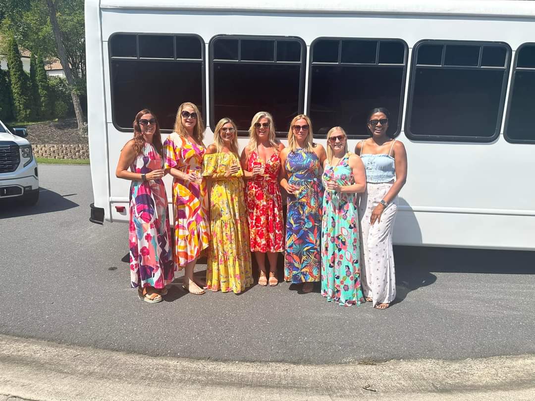 Women in Sundresses Beside a CharlotteLUX White Party Bus