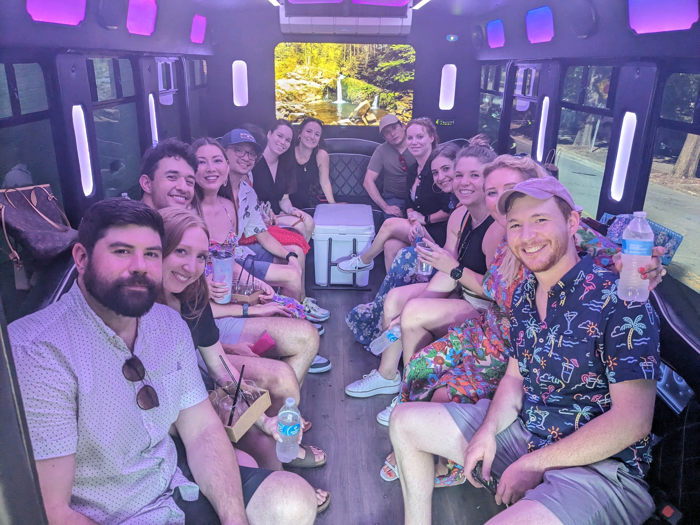 People Smiling & Sitting Inside a CharlotteLUX Party Bus