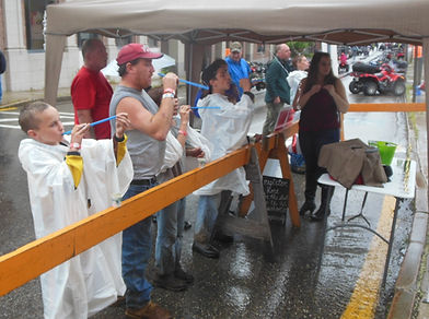A picture of people showing good sportsmanship by participating in the peashooting contest in the pouring rain.