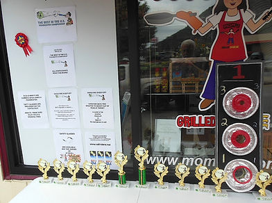 A picture of the peashooting contest held in Berlin NH at MOMz restaurant showing rules, trophies and targets positioned outside the window.