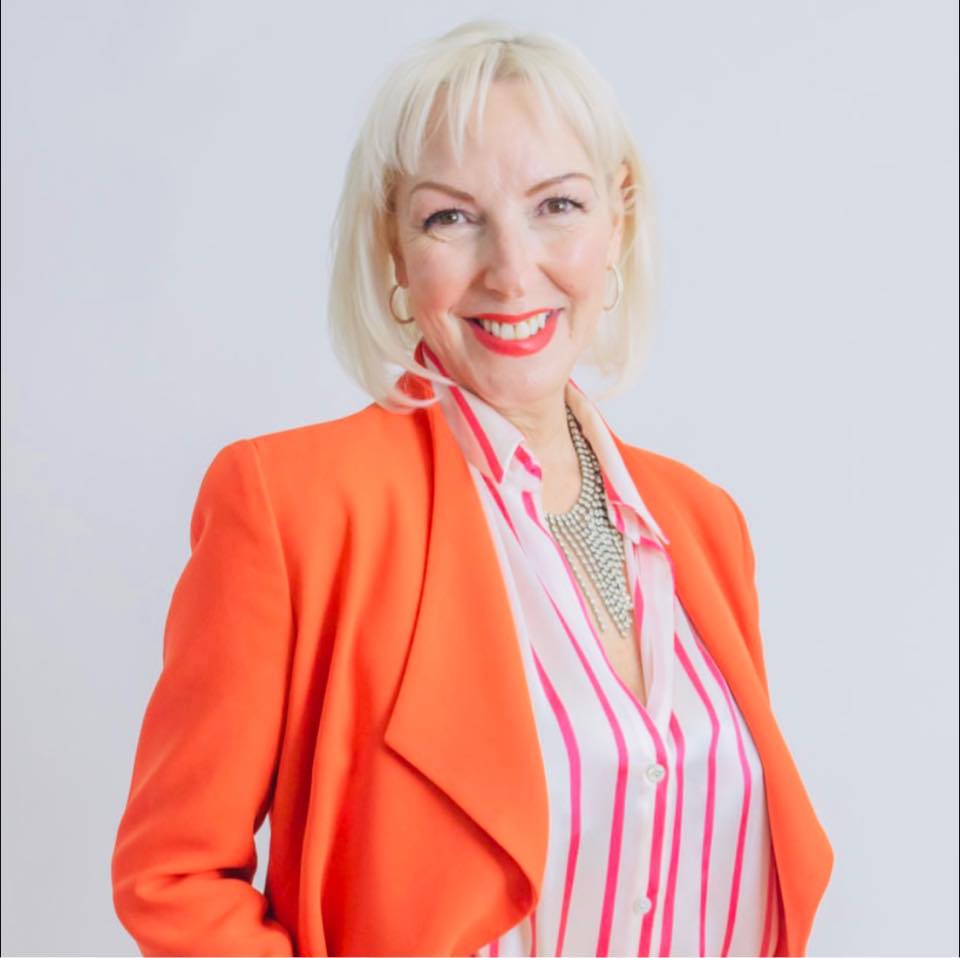 Susie Barber, author and etiquette educator, wearing an orange jacket