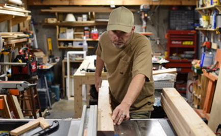 Brent of Meadlowlark Handyman Service cuts wood on a tablesaw.