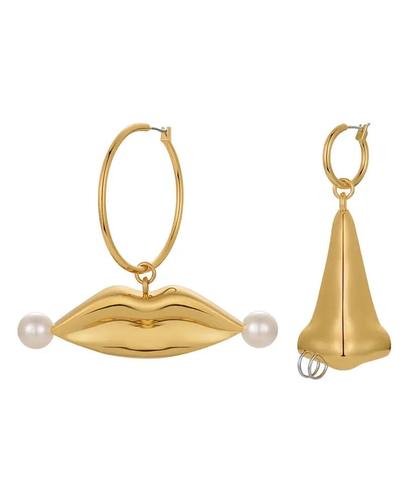 A close-up photo of Cusuti Exaggerated Gold Lip Dangle Earrings which dangle from a clasp of gold-plated environmental brass.