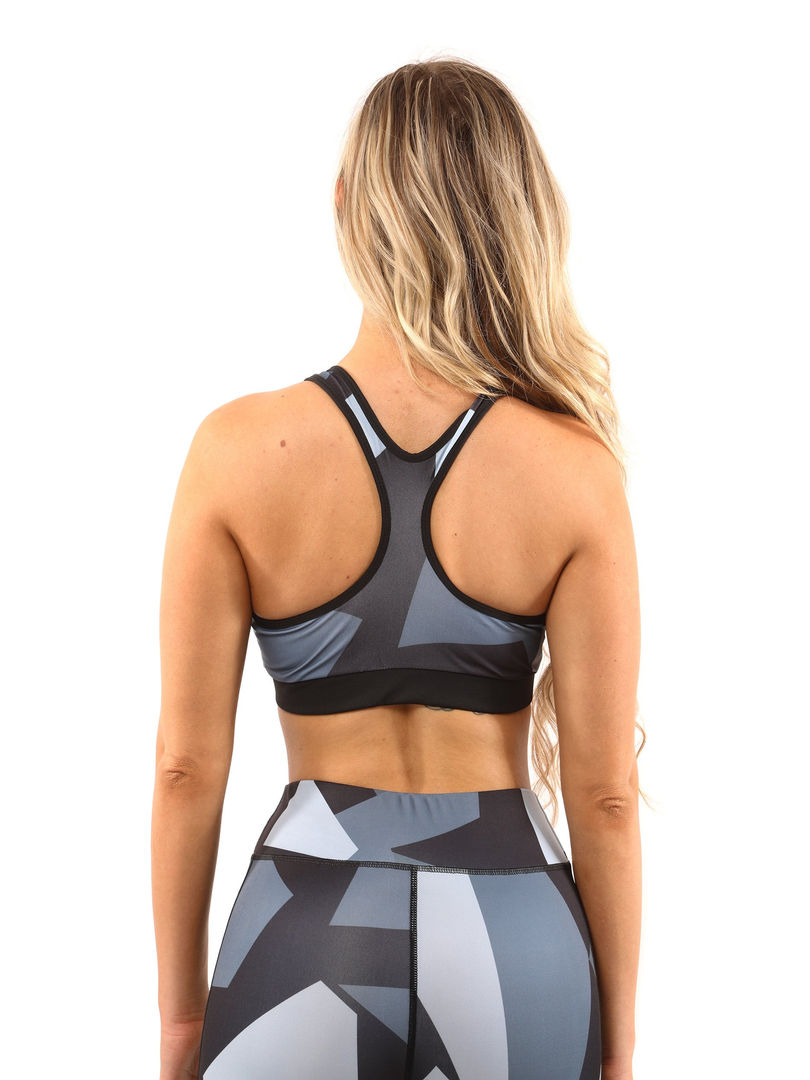 A woman wearing black&white high-waisted compression leggings with a black&white sports bra, working out. Cusuti