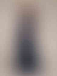 A woman wearing a flowing chiffon evening dress with a V-neckline, featuring delicate appliques, bows, and lace. Cusuti eveni