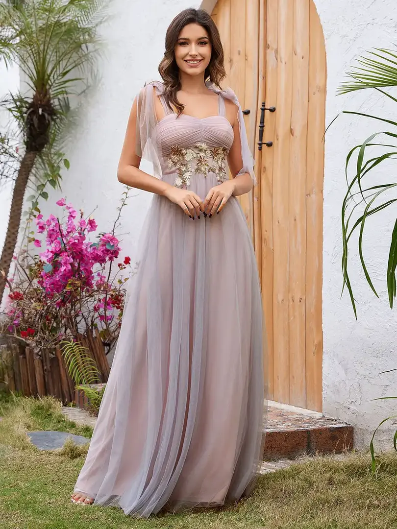 Photo of model wearing a strapless A-line evening dress by Cusuti . The dress is made of polyester tulle and lace appliques.