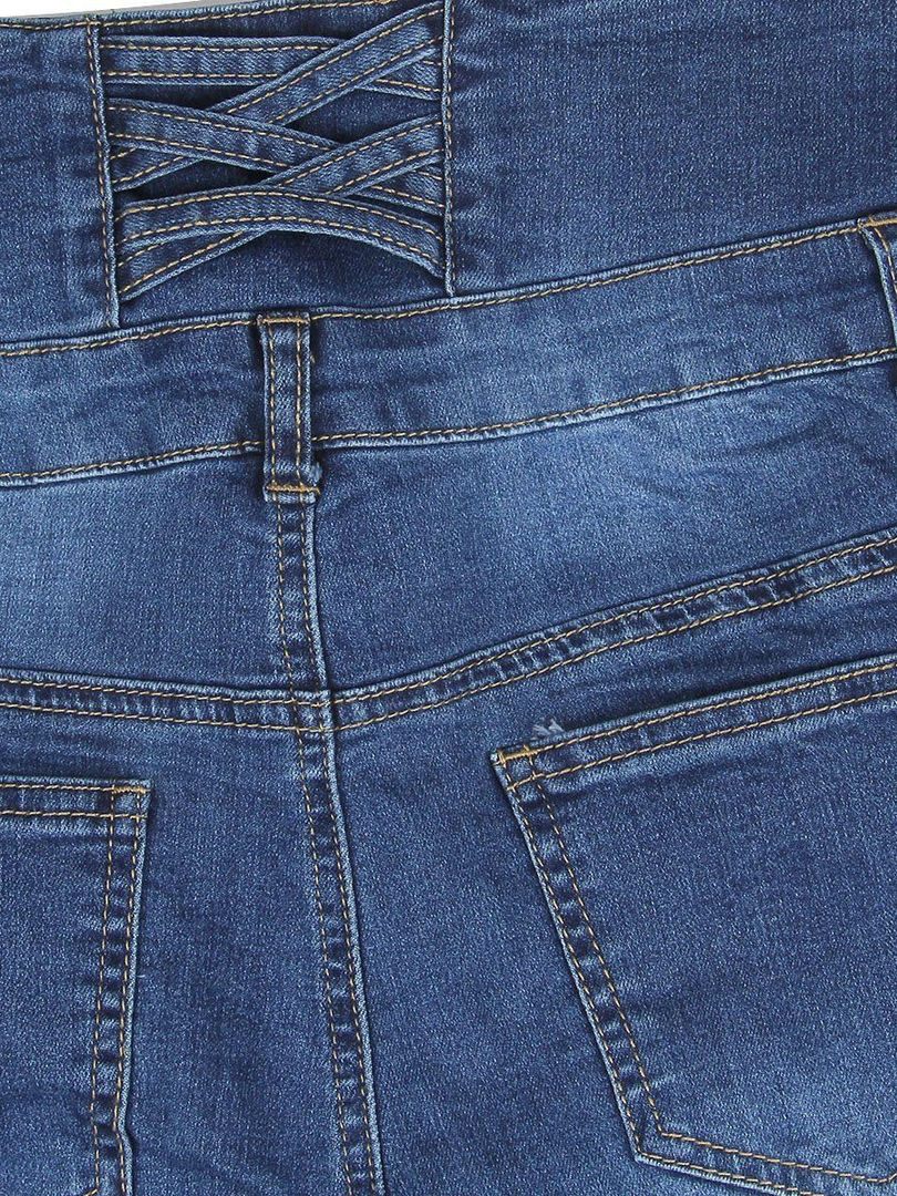 Woman wearing dark wash denim pencil pants with a white button-down shirt and black heels.