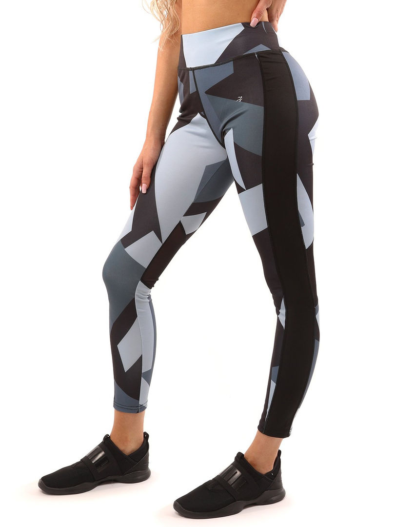 A woman wearing black&white high-waisted compression leggings with a black&white sports bra, working out. Cusuti