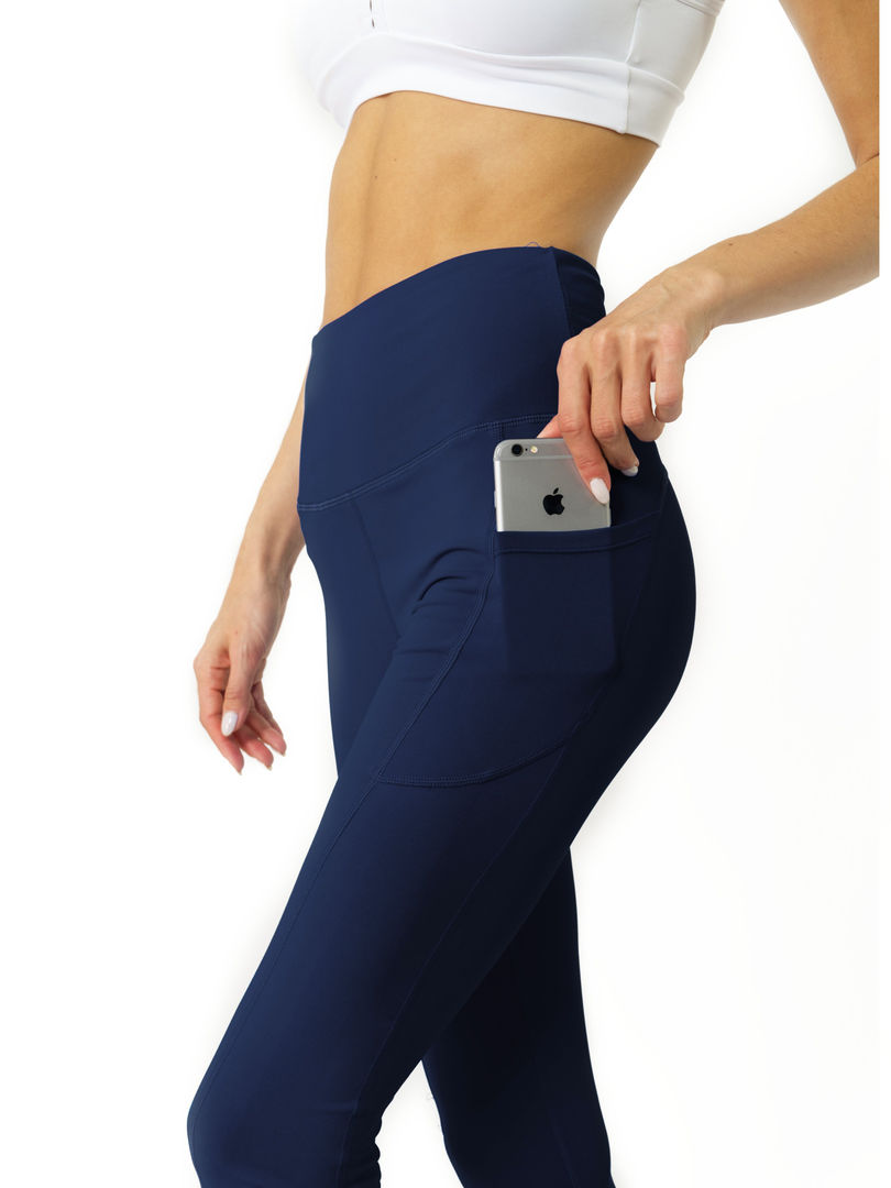 A woman wearing royal blue high-waisted compression leggings with a black sports bra, working out. Cusuti.