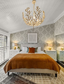 Chic bedroom with textured wallpaper, unique lighting, and curated bedding by Next Chapter Interior Designs