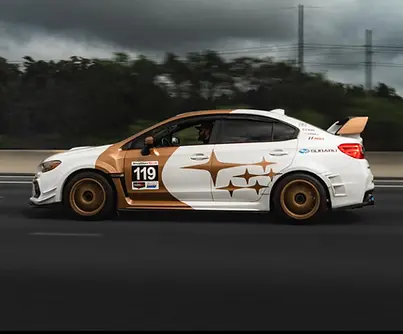 Custom car wrap design for Subaru WRX featuring bronze accents, racing livery, and vinyl graphics by Hawkeye Brothers.