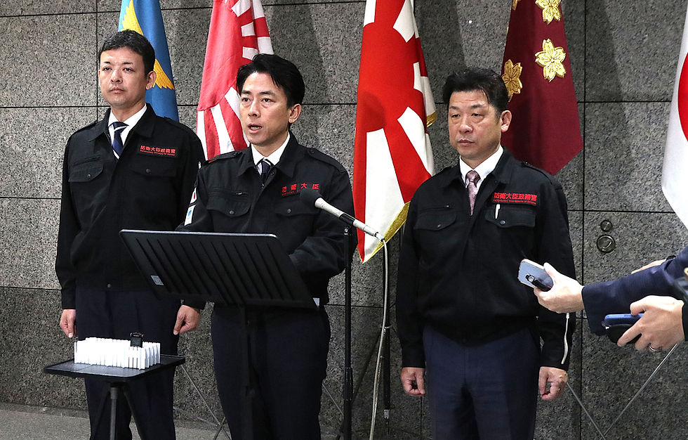 臨時会見を開き、医療機関への給水支援の現状を説明する小泉防衛相(中央)=7月30日、防衛省