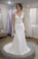Enzoani white lace wedding dress with cap sleeves, beaded belt, and flowing train.