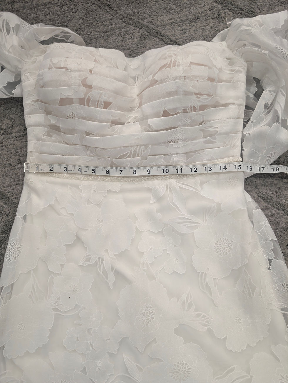 Thumbnail: Elly Size 12 Wedding Dress featuring large floral design and off shoulder sleeves.