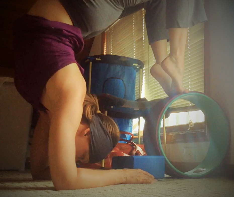 A low quality picture of me working on a Scorpion pose with a Yoga block and my Plexus Yoga Wheel