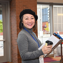 Joyful attendee with clipboard and coffee cup