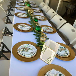 Mesa con mantel blanco, platos base dorados y centro de hojas - Fiestalandia Panamá