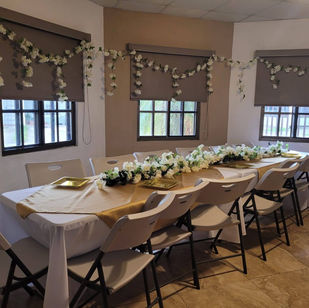 Mesa rectangular con mantel blanco y camino de flores - Fiestalandia Panamá