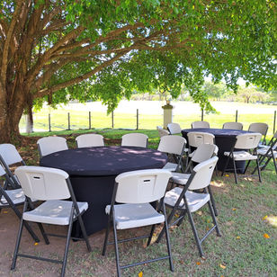 Mesa redonda con mantel negro y sillas plegables en jardín - Fiestalandia Panamá