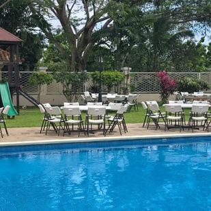 Mesas junto a la piscina en jardín - Fiestalandia Panamá