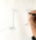 une main dessinant un luminaire sur pied