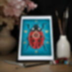 mockup d'une cadre A4 sur meuble avec une reproduction d'art d'une coccinelle sur fond bleu