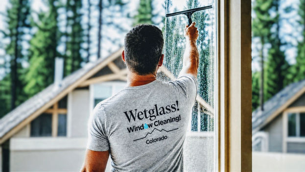 A Wetglass technician cleaning interior windows.