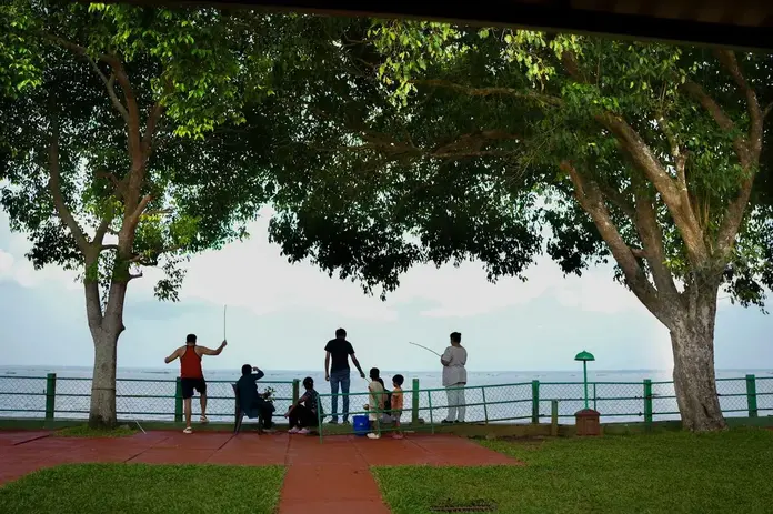 Guests fishing using fishing rod in the premises of Lake facing Family/Superior cottage. At Illikkalam Lakeside Cottages, Kumarakom.