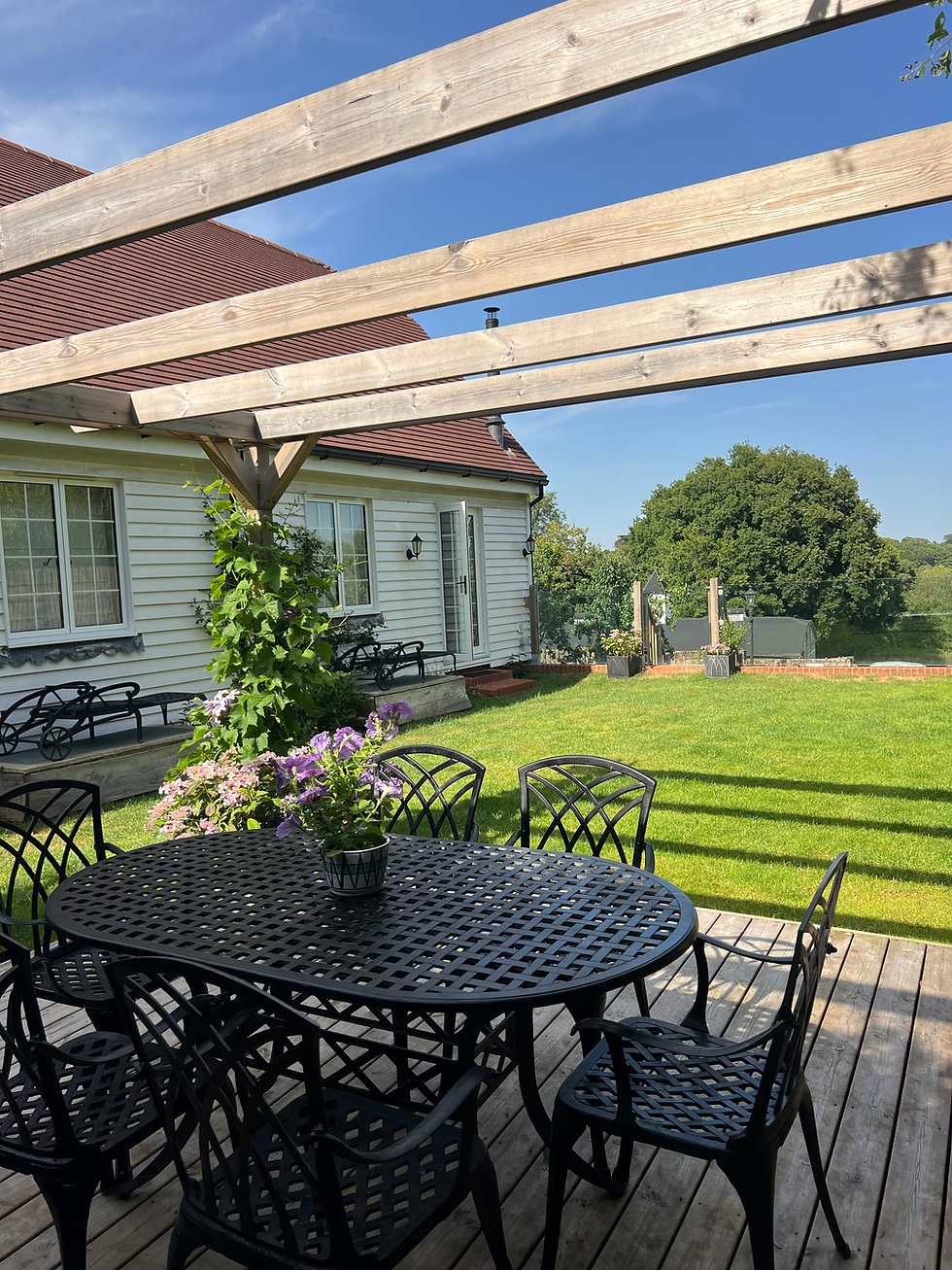 Enclosed garden with outdoor dining and BBQ at Judins Cottage, Burwash