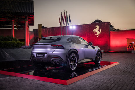 A Ferrari parked in front of a luxury hotel at a car launch