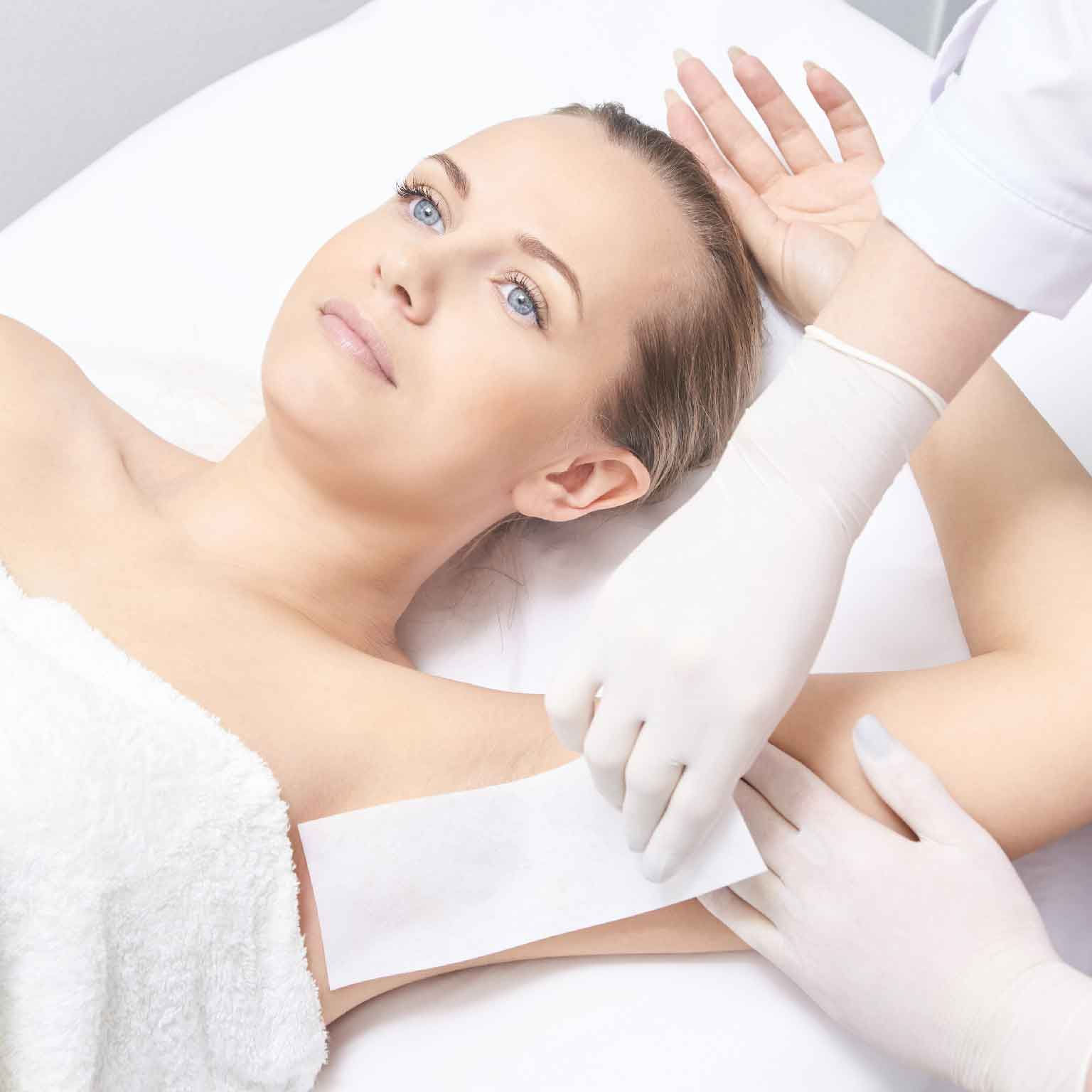 woman's underarm being waxed