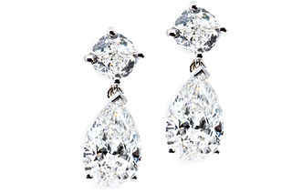 18k White Gold Dangle Earrings featuring two solitaire Cushion diamonds and two solitaire Pear shaped diamonds with a total carat weight of 6.07 carats. All Stones are GIA certified
