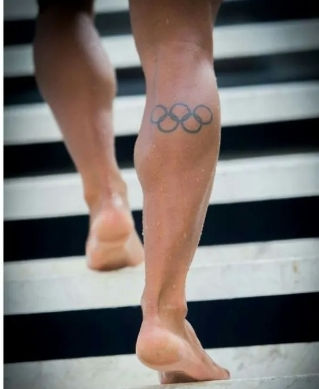 Olympian with leg tattoo walking up stairs