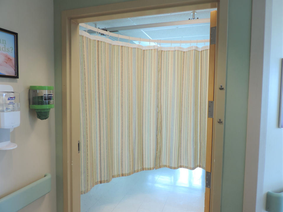 Patient room featuring round hospital curtain track surrounding the bed