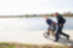 Two gay dads teaching son, who was birthed through surrogacy for same sex couples, how to ride a bike