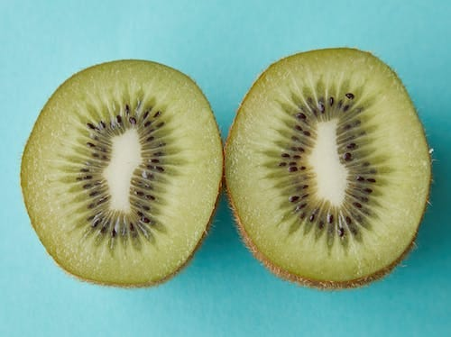 A healthy & tasty kiwi sliced in two halves.