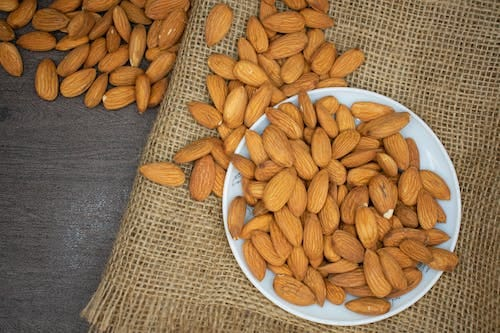 Almonds spread on the plate and table.