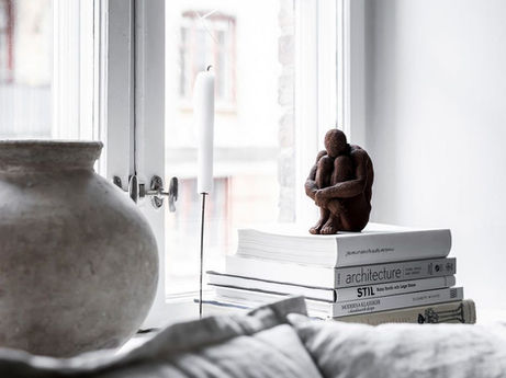 A window seat layered in texture, anchored by sculpture and thought.