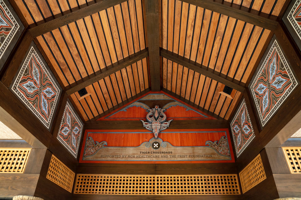 Decorative wooden ceiling detail inside the exhibit space, featuring painted panels and intricate geometric patterns.