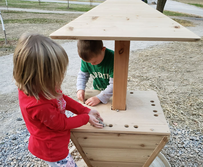 Children explore a touch-focused station with spinning texture blocks.