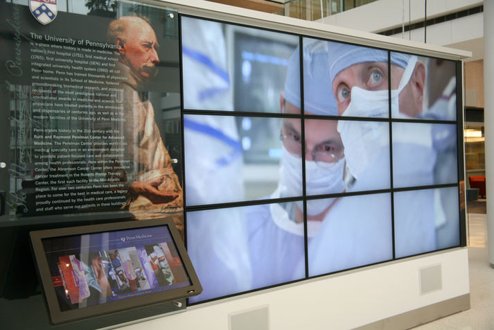 Wall installation with surgical imagery and a text panel highlights the University of Pennsylvania’s medical legacy.
