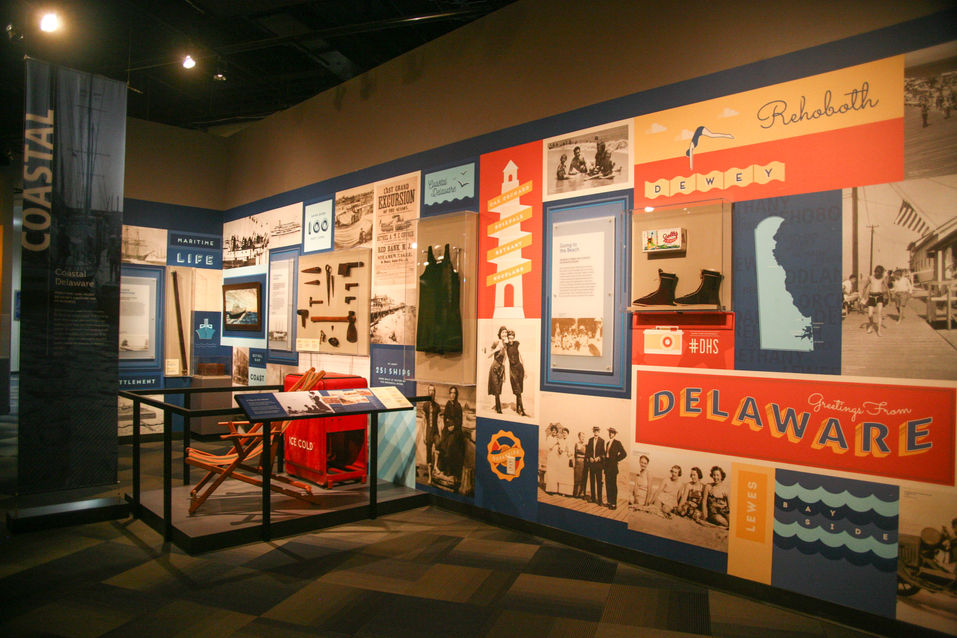 Colorful wall mural dedicated to Delaware's coastal and social history, integrating graphics, photographs, artifacts, and signage.