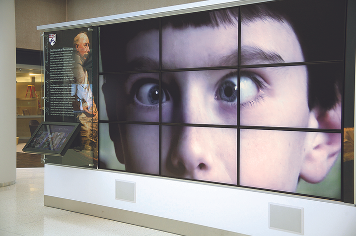 Close-up of a child's face across multiple monitors in a high-resolution video wall exhibit.
