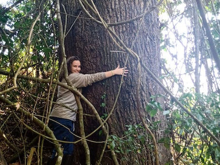 Foto einer jungen Frau, die einen Baum umarmt/Privates Archiv