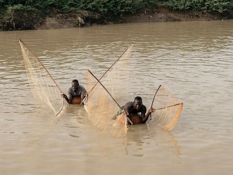 Fischer verwenden Netze, um Fische zu fangen, während sie auf Kalebassen im Sokoto-Fluss liegen, der lokal als Maten Fada bezeichnet wird, in Argungu, Kebbi State, im Norden Nigerias, am 12. April 2025. (Foto von Suzanne Lassen / AFP)